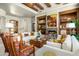 Bright living room featuring a fireplace, travertine floors, wood beams, and comfortable seating at 10531 E Cinder Cone Trl, Scottsdale, AZ 85262