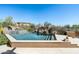 Relaxing swimming pool features a waterfall feature surrounded by desert landscaping at 10531 E Cinder Cone Trl, Scottsdale, AZ 85262