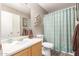 A well-lit bathroom features a decorative mirror, cabinet, and a combined shower and bathtub at 10566 E Bogart Ave, Mesa, AZ 85208