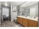 Bright bathroom with double sinks, a large mirror, and wood-look tile flooring at 10566 E Bogart Ave, Mesa, AZ 85208