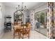 Dining area with wood table, chairs, decorative mirror, and sliding glass door to the backyard at 10566 E Bogart Ave, Mesa, AZ 85208