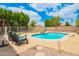 Inviting backyard pool with stone patio, lush greenery, and comfortable seating, perfect for relaxation and entertainment at 10566 E Bogart Ave, Mesa, AZ 85208