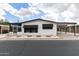 Charming exterior of a white single-story home with dark shutters and a carport at 11000 N 91St Ave # 101, Peoria, AZ 85345