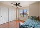 Bedroom with wood floors, ceiling fan, closet, and a sunlit window at 11106 E Clinton St, Scottsdale, AZ 85259