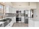 Modern kitchen with stainless steel appliances, white cabinets, and granite countertops at 11106 E Clinton St, Scottsdale, AZ 85259