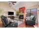 Inviting living room boasting a fireplace, leather recliners, and hardwood floors providing cozy charm at 11106 E Clinton St, Scottsdale, AZ 85259