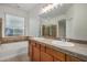 Bathroom featuring a double vanity, tub, and shower with decorative tile at 12451 W Nadine Way, Peoria, AZ 85383