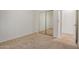 Bedroom with neutral carpet, double mirrored closet doors, and access to hall at 12451 W Nadine Way, Peoria, AZ 85383