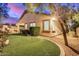 Well-maintained exterior showcasing lush landscaping, a stone patio, and charming outdoor features for curb appeal at 12451 W Nadine Way, Peoria, AZ 85383