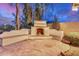 Backyard fireplace and stone patio with ample seating space, perfect for outdoor gatherings and cozy evenings at 12451 W Nadine Way, Peoria, AZ 85383