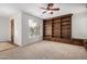 Spacious living room featuring a built-in bookshelf, plush carpeting, and a ceiling fan at 12451 W Nadine Way, Peoria, AZ 85383