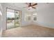 Bright living room featuring neutral carpet, built-in shelving, and sliding glass doors to the patio at 12451 W Nadine Way, Peoria, AZ 85383