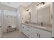 Stylish bathroom with dual sinks, granite countertop, white cabinetry, and matte black hardware at 12937 W El Sueno Ct, Sun City West, AZ 85375
