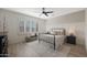 Bright bedroom with plantation shutters, wood floors, accent wall, ceiling fan, and comfortable furnishings at 12937 W El Sueno Ct, Sun City West, AZ 85375