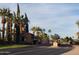 Community entrance featuring guard house, multiple palm trees and signage at 12937 W El Sueno Ct, Sun City West, AZ 85375