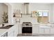 Stylish kitchen with stainless steel appliances, white cabinets, and floating shelves at 12937 W El Sueno Ct, Sun City West, AZ 85375