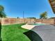 Well-manicured backyard featuring an in-ground pool, artificial turf, and a privacy fence at 13620 N 82Nd Ln, Peoria, AZ 85381