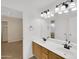 Bathroom with double sink vanity, and bright lighting fixtures, adjoining bedroom at 13620 N 82Nd Ln, Peoria, AZ 85381