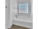 Modern white bathtub beneath the glass block window with tile floors and chrome fixtures at 13620 N 82Nd Ln, Peoria, AZ 85381