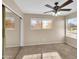 Neutral bedroom with a ceiling fan, large window, and closet with sliding mirror doors at 13620 N 82Nd Ln, Peoria, AZ 85381
