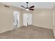 Bright bedroom features a ceiling fan and doorways to other rooms and neutral carpeting at 13620 N 82Nd Ln, Peoria, AZ 85381