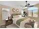 Bright, airy bedroom with neutral colors, decorative mirrors, ceiling fan and large windows at 13620 N 82Nd Ln, Peoria, AZ 85381