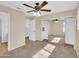 Bright bedroom with ceiling fan, mirror sliding closet doors, and neutral carpeting at 13620 N 82Nd Ln, Peoria, AZ 85381