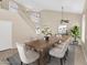 Elegant dining room featuring a rustic wood table, upholstered chairs, and natural light from the grand staircase at 13620 N 82Nd Ln, Peoria, AZ 85381