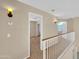 Bright hallway featuring neutral walls, white railing, and warm lighting fixtures at 13620 N 82Nd Ln, Peoria, AZ 85381