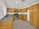Kitchen featuring granite countertops, stainless steel appliances, and wood cabinetry at 13620 N 82Nd Ln, Peoria, AZ 85381