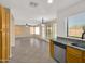 Kitchen open to living room featuring granite countertops, stainless steel appliances, and wood cabinetry at 13620 N 82Nd Ln, Peoria, AZ 85381