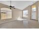 Inviting living room featuring tile floors, neutral paint, high ceilings, a fan, and bright natural light at 13620 N 82Nd Ln, Peoria, AZ 85381