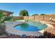 An inviting backyard pool with stone border, lush plants, and a covered patio for relaxation at 13620 N 82Nd Ln, Peoria, AZ 85381