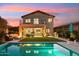 An outdoor oasis featuring a pool, fire pit, covered patio, and lush landscaping illuminated at dusk at 15711 S 11Th Ave, Phoenix, AZ 85045