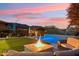 Serene backyard retreat showcasing a pool, fire pit, outdoor seating, and mountain views at sunset at 15711 S 11Th Ave, Phoenix, AZ 85045