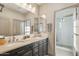 A modern bathroom with dual sinks, a large mirror, and a glass-enclosed shower at 15711 S 11Th Ave, Phoenix, AZ 85045