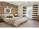 Stylish bedroom features a brick wall, modern art, and plenty of natural light at 15711 S 11Th Ave, Phoenix, AZ 85045
