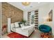 Cozy bedroom featuring a brick accent wall, natural light, a plush bed, and modern furnishings at 15711 S 11Th Ave, Phoenix, AZ 85045