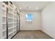 Well-lit bonus room featuring white shelving units with black trim and a view through a single window at 15711 S 11Th Ave, Phoenix, AZ 85045