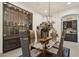 Elegant dining room with a glass table, stylish chairs, unique lighting, and a custom wine display at 15711 S 11Th Ave, Phoenix, AZ 85045