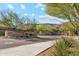 Community entrance with a stone sign, mature landscaping, and a gated entry for security at 15711 S 11Th Ave, Phoenix, AZ 85045