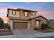 Charming two-story home with a stone facade, and warm exterior lighting at dusk at 15711 S 11Th Ave, Phoenix, AZ 85045