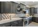 Elegant kitchen features dark wood cabinets, stainless steel range, and eye-catching geometric backsplash at 15711 S 11Th Ave, Phoenix, AZ 85045