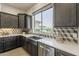 Modern kitchen with a stainless steel farmhouse sink, white countertops, and geometric tile backsplash at 15711 S 11Th Ave, Phoenix, AZ 85045