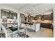 Open-concept kitchen features a dining area, dark cabinetry, island with seating, and stainless steel refrigerator at 15711 S 11Th Ave, Phoenix, AZ 85045
