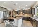 Spacious kitchen boasts a large center island with bar stools, dark cabinetry, and stainless steel appliances at 15711 S 11Th Ave, Phoenix, AZ 85045