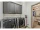 Convenient laundry room with modern washer and dryer units and dark wood cabinetry, leading to a walk-in closet at 15711 S 11Th Ave, Phoenix, AZ 85045