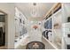 A large, modern walk-in closet features custom storage, shelving, and an island with a glass table at 15711 S 11Th Ave, Phoenix, AZ 85045