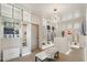 Bright walk-in closet featuring custom shelves, cabinets, closet island, stylish lighting, and a comfortable sitting area at 15711 S 11Th Ave, Phoenix, AZ 85045