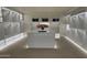 Bright walk-in closet featuring custom shelving, a center island, carpeted floors and soft, modern lighting at 15711 S 11Th Ave, Phoenix, AZ 85045
